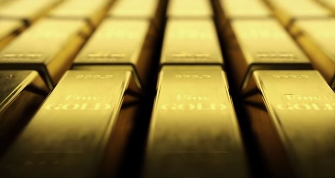 Goldbarren liegen in einer geordneten Reihe.